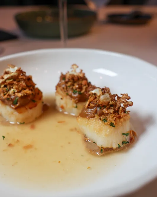New Jersey scallops served with cauliflower, almond, and Ibérico consommé at Restaurant Latour.