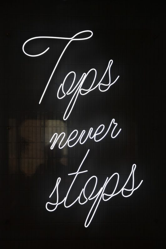 “Tops Never Stops” neon sign
