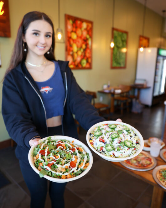 young woman holding salads from worldFLATS