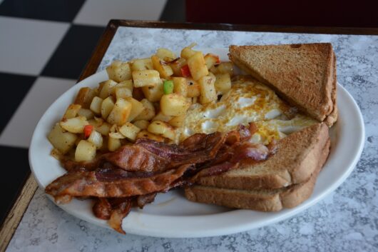  a plate of Eggs over easy with bacon and potatoes