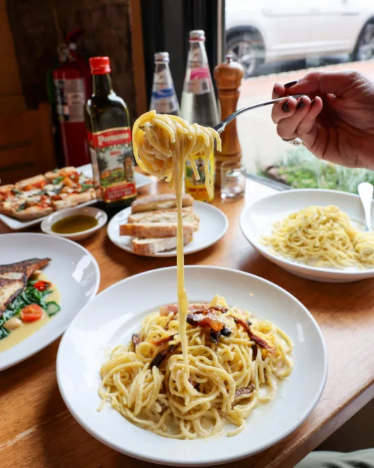 Creamy spaghetti carbonara on a fork with pancetta from Luigino’s Parmigiana in Montclair New Jersey