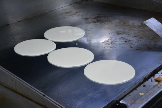 Pancakes cooking on a flat-top griddle at Ridge Diner in Park Ridge New Jersey