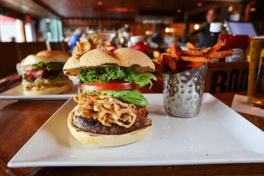 The award-winning Angus burger from Harpoon Willy's in Wall, New Jersey, topped with melted cheese, lettuce, tomato, and served on a toasted bun with fries.