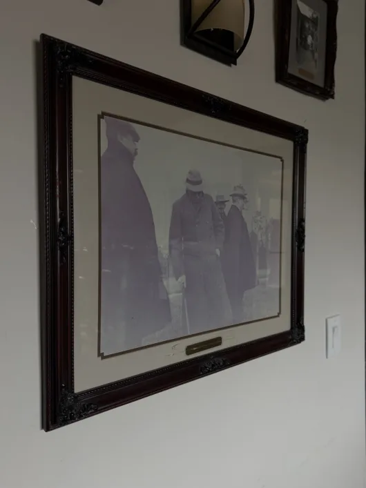 old photos hang on the wall of the Claflin house