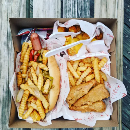 Mayfair Italian Hot Dog with Crinkle-Cut Fries An Italian hot dog from Mayfair Boardwalk Grill topped with peppers, onions, potatoes, and crinkle-cut fries in Asbury Park, New Jersey.