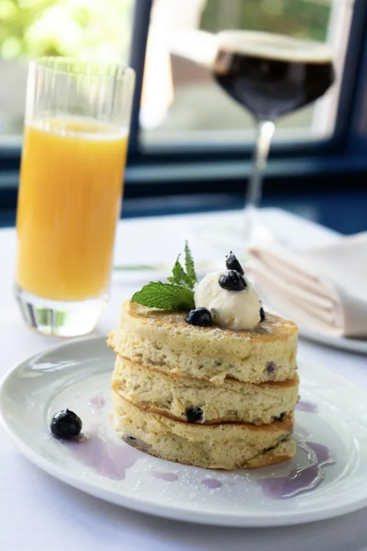 Stack of Blueberry Buttermilk Pancakes served with fresh blueberries and Vermont maple syrup at The Carriage House in Millburn, NJ.