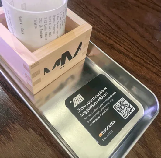 twocents QR code card displayed on a restaurant table inviting guests to share private feedback directly with management.