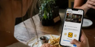 A restaurant guest uses the twocents app on her smartphone to share private feedback about her dining experience.
