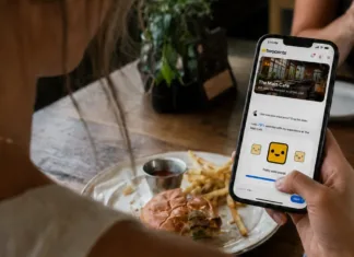 A restaurant guest uses the twocents app on her smartphone to share private feedback about her dining experience.