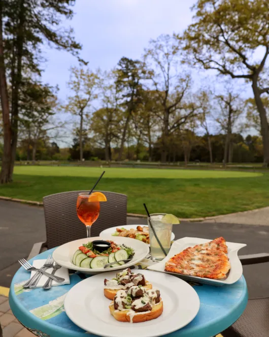 table of food and view of the golf course from the Tiki Bar
