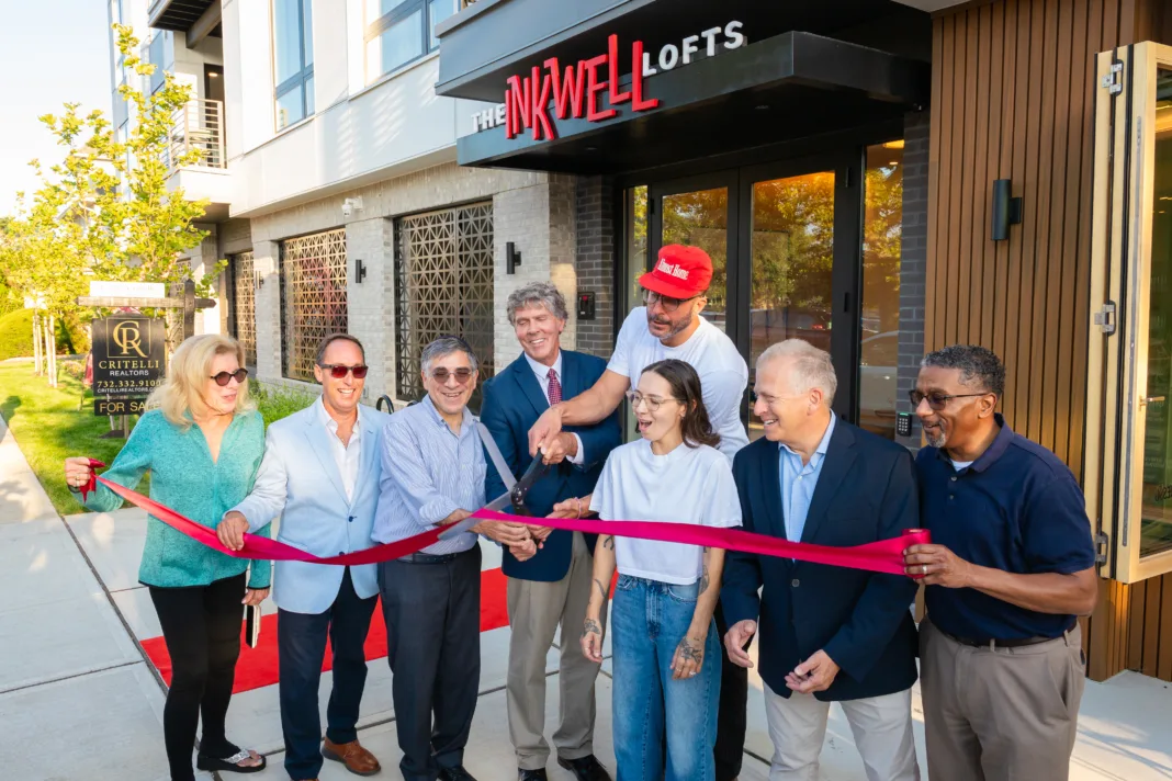 IMG_5519 Group of people pose outside The Inkwell Lofts during a ribbon-cutting ceremony celebrating the opening of the venue.