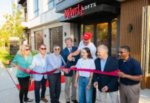 Group of people pose outside The Inkwell Lofts during a ribbon-cutting ceremony celebrating the opening of the venue.