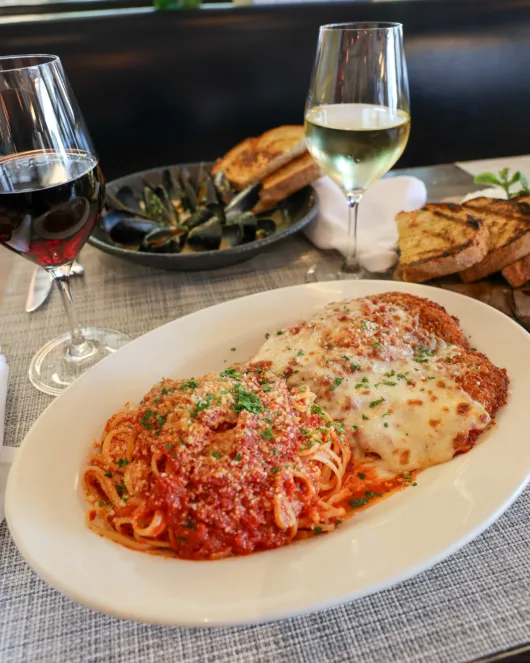 Chicken Parmesan topped with melted cheese and tomato sauce served with pasta at Beneci’s D’Italia Cucina in Weehawken, NJ