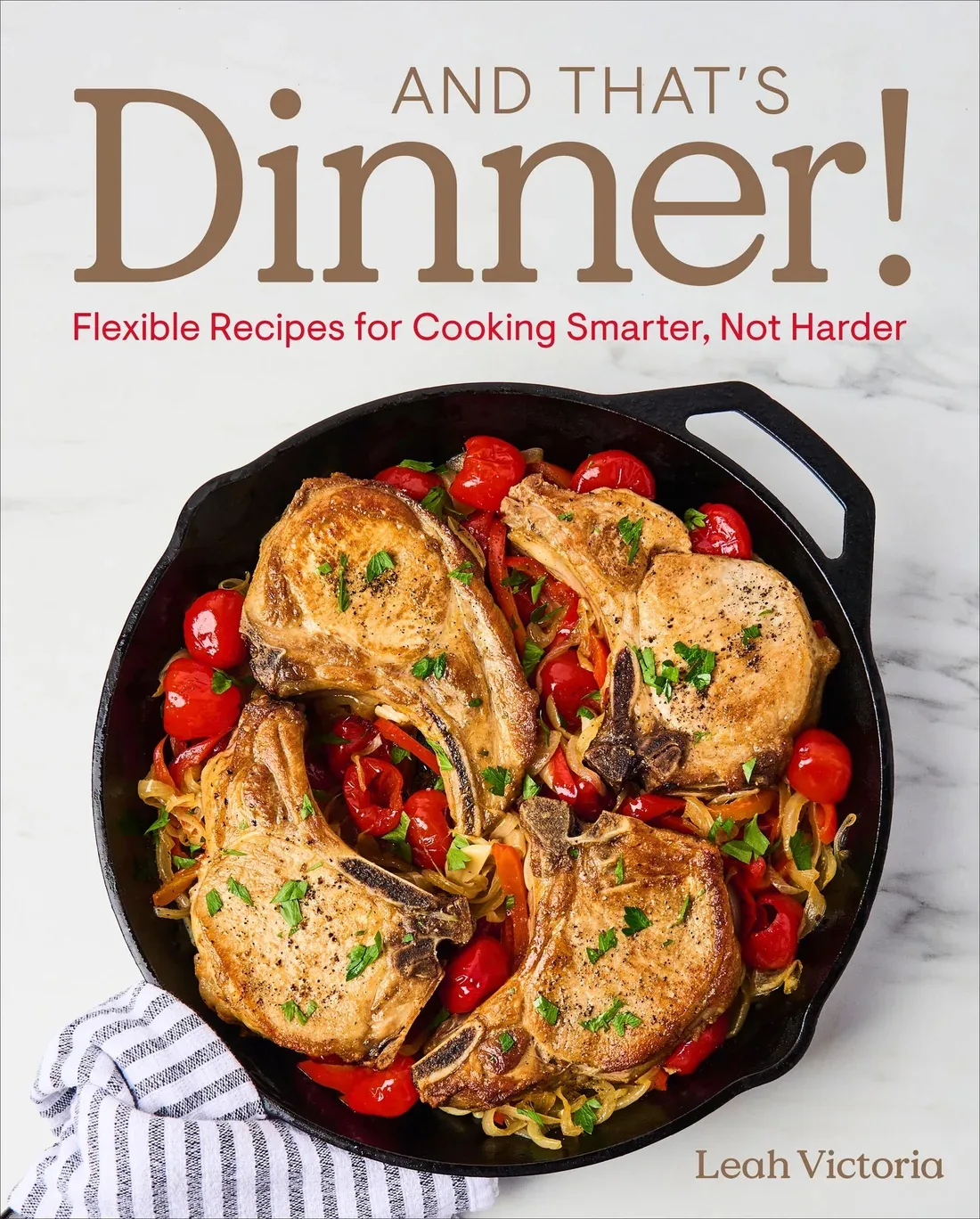 Cover of “And That’s Dinner!” by Leah Victoria, featuring four golden-brown pork chops in a cast-iron skillet with tomatoes, onions, peppers, and fresh herbs.