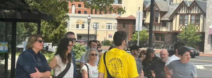 A group gathers for a guided Chow Town food tour on a sunny day in downtown New Jersey.